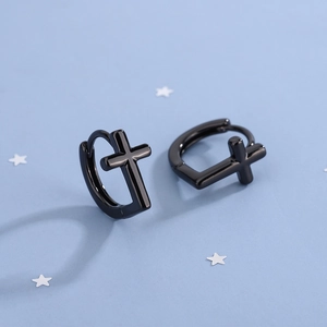 Detail shot of black polished cross earrings showing glossy finish and mirror-like surface