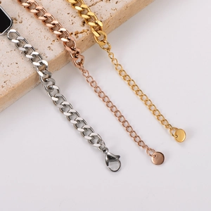 Detail of three-tone cuban chain bracelets with lobster clasp and round tag on stone