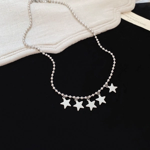 Detail shot of five silver star pendants hanging from a classic bead chain necklace