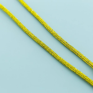 Macro shot of sparkling yellow rhinestone crossbody chain with polished finish