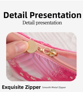 Macro shot of a smooth gold metal zipper on a pink star pattern polyester cosmetic bag