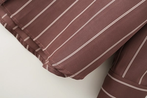 Close-up of brown and white striped shirt fabric with precise stitching details