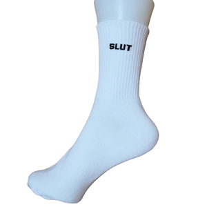 White cotton ribbed crew socks featuring bold black SLUT text on the ankle band