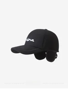 Close-up of black winter cap featuring ear flaps and white ina letter embroidery
