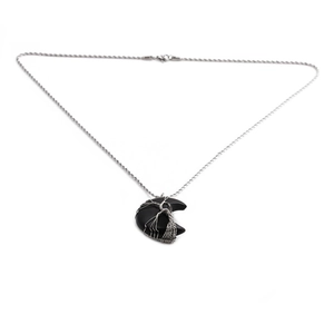 Close-up of tree of life wire-wrapped crescent moon crystal pendant on silver chain