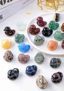 Macro shot of assorted natural crystal duck carvings in a white porcelain dish