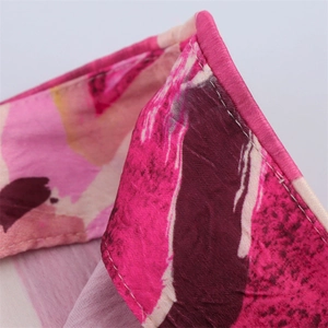 Detail of pink floral print satin skirt showing neat hem stitching and smooth fabric texture