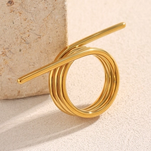 Makroaufnahme des 18K vergoldeten Edelstahl-Spiralrings auf einem strukturierten Stein
