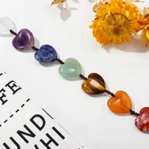 Detail of hand-woven Seven Chakra heart-shaped natural stones with polished textures