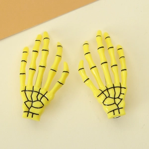 Detail of yellow skeleton hand hair clips with black joint lines for Halloween party decor