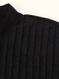 Close-up of pleated pintuck details on the shoulder of a black vacation-style dress