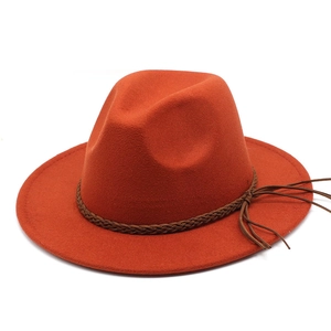 Detail of orange fedora wool hat featuring a braided leather band with stylish tassels