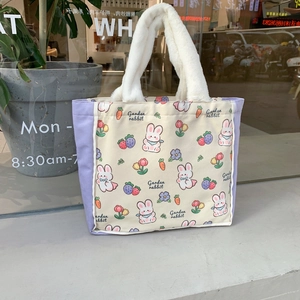Macro detail of the plush white handle and cartoon rabbit canvas tote bag texture