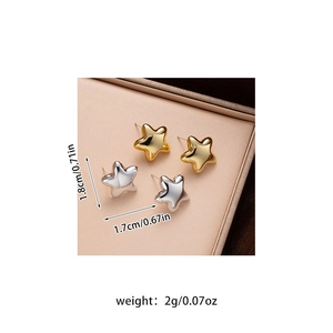 Detail view of gold and silver star stud earrings with size and weight measurements