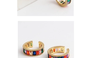 Close-up of golden ear cuff with inlaid rectangular rainbow cubic zirconia crystals
