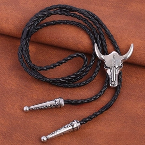 Close-up of vintage silver bull skull pendant on braided leather bolo tie necklace