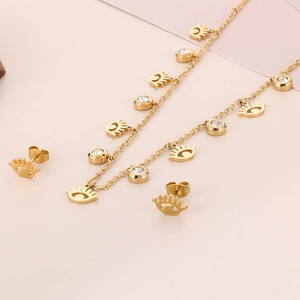Detailed view of gold eye-shaped necklace and earrings set with sparkling crystals