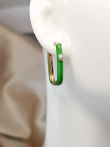 Close-up of green enamel U-shape hoop earring with zircon inlay on a model ear