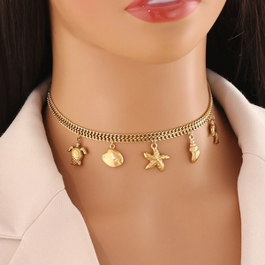 Golden ocean theme necklace with turtle, shell and starfish pendants on a female model