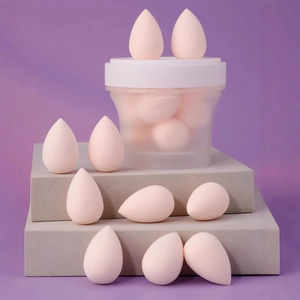 Set of 10 mini teardrop makeup sponges in a translucent frosted storage jar