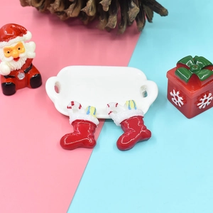 Mini red resin Christmas stockings with candy cane decor on a festive holiday tray