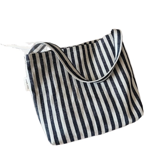 Blue and white striped canvas tote bag with simple wish label and flat minimal design