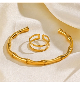 Detail of 18K gold plated stainless steel bamboo style ring and bracelet on silk