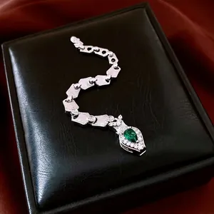 Exquisite silver snake ring with sparkling zircons and a pear-shaped green gemstone