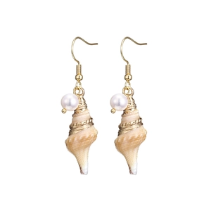 Detail of golden seashell earrings featuring natural shell texture and white pearls