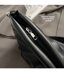 Détail de la fermeture éclair en métal et du cuir noir mat sur le grand sac cabas