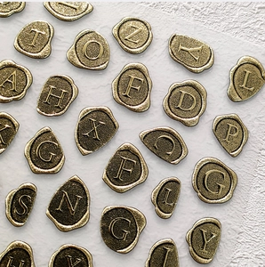 Vue macro de sceaux autocollants dorés avec lettres de l'alphabet et relief 3D métal