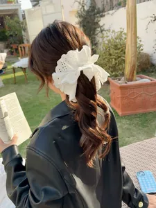 Close-up of white lace scrunchie with embroidery detailing for ponytail styling