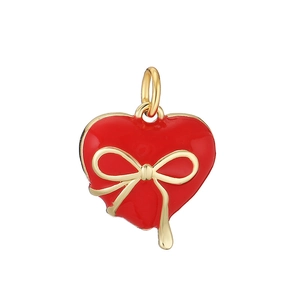 Detail of a red enamel heart pendant with a gold bow accent and a top hanging ring
