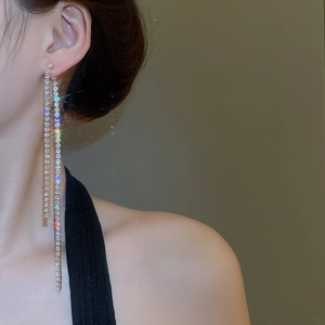 Detail view of long silver tassel earrings with zircon studs on a model side profile
