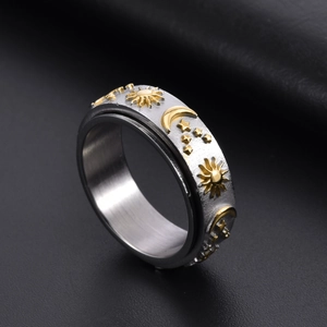 Stainless steel celestial spinning ring with gold sun, moon, and star relief patterns