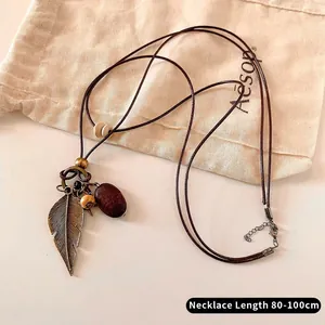 Detail of vintage bohemian necklace with bronze feather, wood bead and 80-100cm cord
