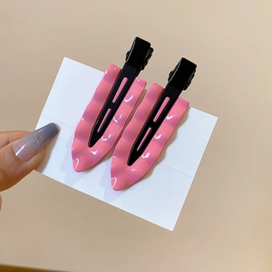 Detail of pink wavy pattern hair clips with classic black metal duckbill grips for women