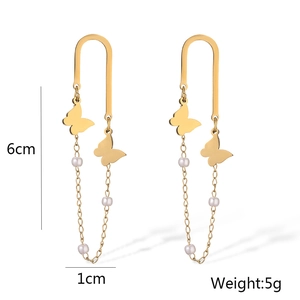 Detail view of gold butterfly tassel earrings with pearls and dimensions 6cm by 1cm