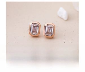 Primer plano de pendientes de titanio oro rosa con circonita rectangular de corte paso