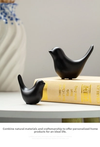 Close-up of minimalist black matte ceramic bird figurines in a modern home setting