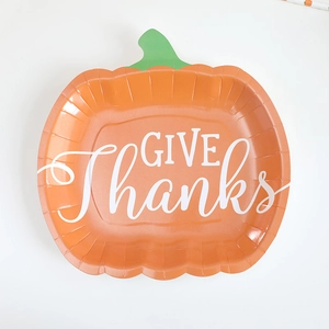 Orange pumpkin shaped paper plates with Give Thanks text for Thanksgiving party decor