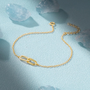 Detail of gold-plated S925 silver bracelet featuring interlocking rings and cubic zirconia