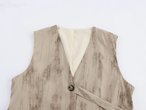 Dettaglio ravvicinato del gilet beige con scollo a V, trama effetto legno e bottone singolo