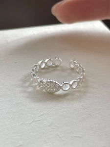 Detailed view of silver fish-shaped adjustable ring with sparkling cubic zirconia accents