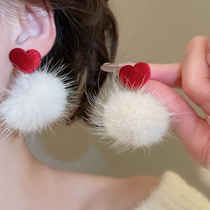 Vue détaillée des boucles d'oreilles cœur en velours rouge et pompons en fourrure