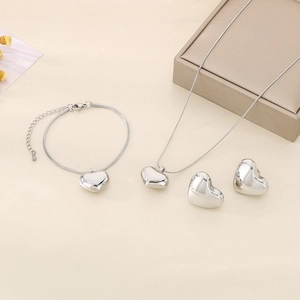 Detailed view of silver heart jewelry set featuring necklace, bracelet and earrings