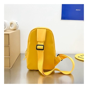 Dettaglio di un borsello giallo per bambini con tracolla regolabile su sfondo moderno