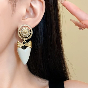 Detailed close-up of vintage heart earrings with bow design and gold-tone finish