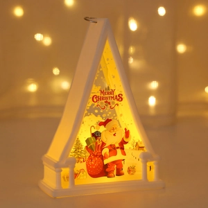 Close-up of white Christmas LED lantern with Santa Claus illustration and warm light glow