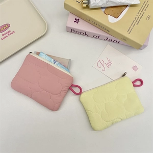Close-up of quilted cloud texture on pink and yellow mini pouches with zipper detail